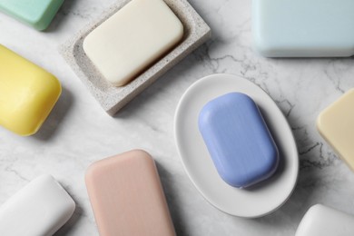 Photo of Many different soap bars on white marble table, flat lay