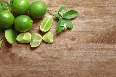 Photo of Composition with fresh ripe limes on wooden background, top view