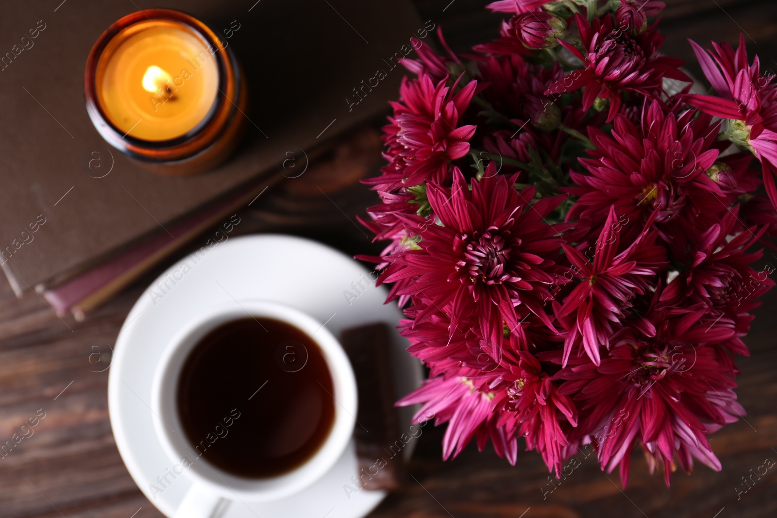 Photo of Composition with beautiful pink chrysanthemum flowers and cup of aromatic tea on wooden table, top view. Space for text