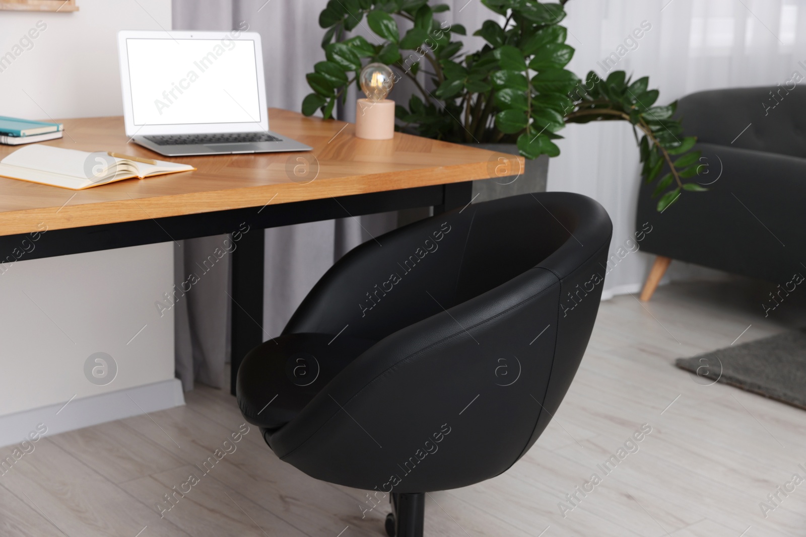 Photo of Comfortable office chair near desk in modern workplace