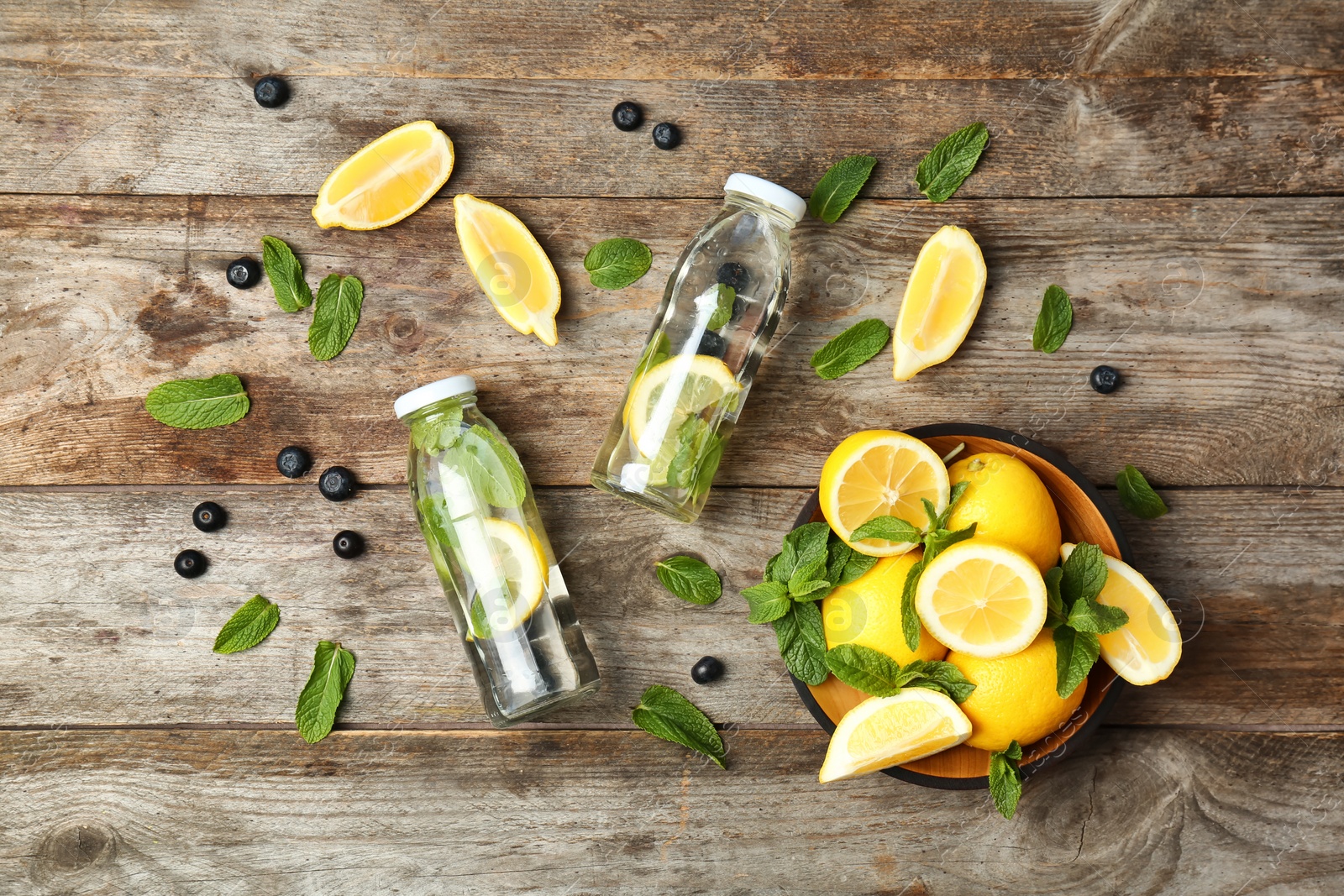 Photo of Flat lay composition with detox lemonade and ingredients on wooden background