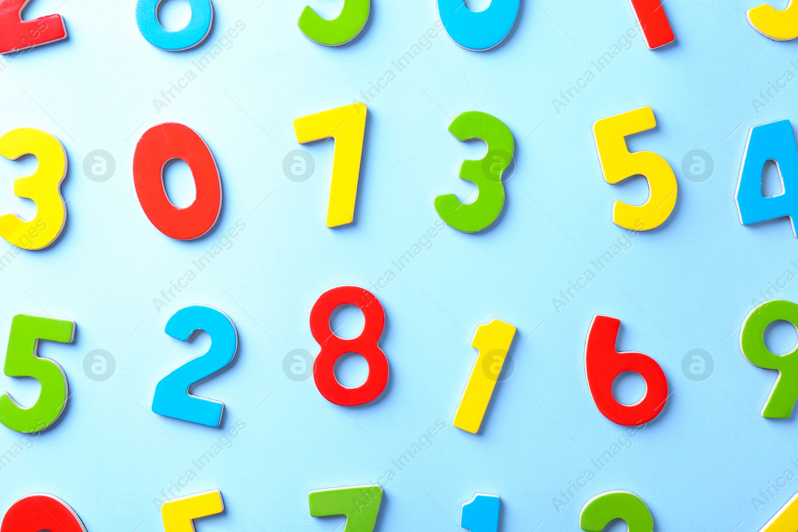 Photo of Colorful numbers on light blue background, flat lay