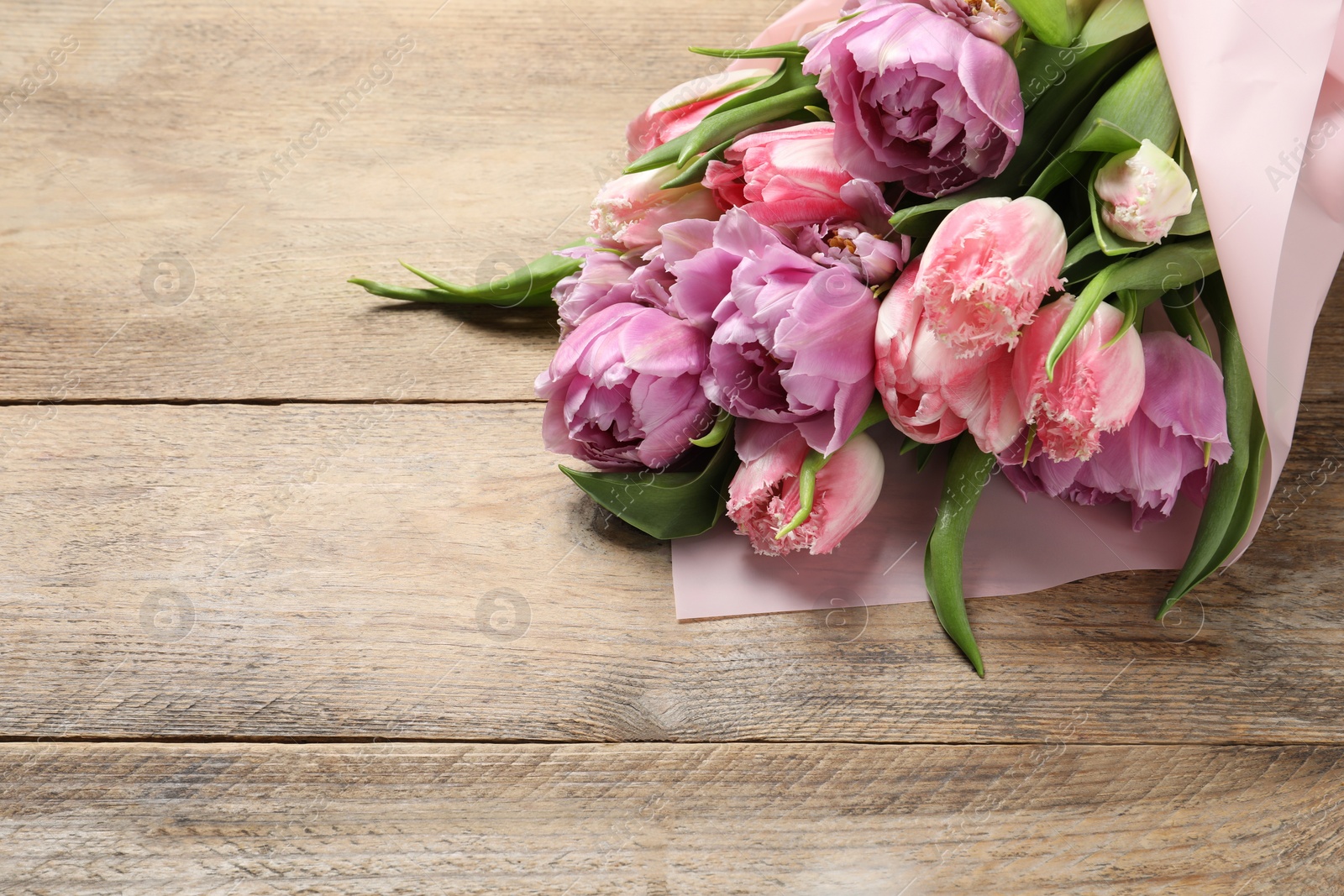 Photo of Beautiful bouquet of colorful tulip flowers on wooden table