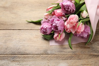 Beautiful bouquet of colorful tulip flowers on wooden table