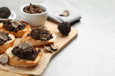 Photo of Delicious bruschettas with truffle sauce on light table. Space for text