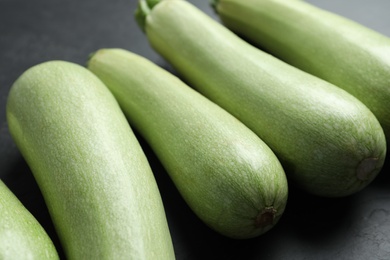 Raw green zucchinis on black slate table, closeup