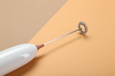 Photo of White milk frother wand on color background, closeup