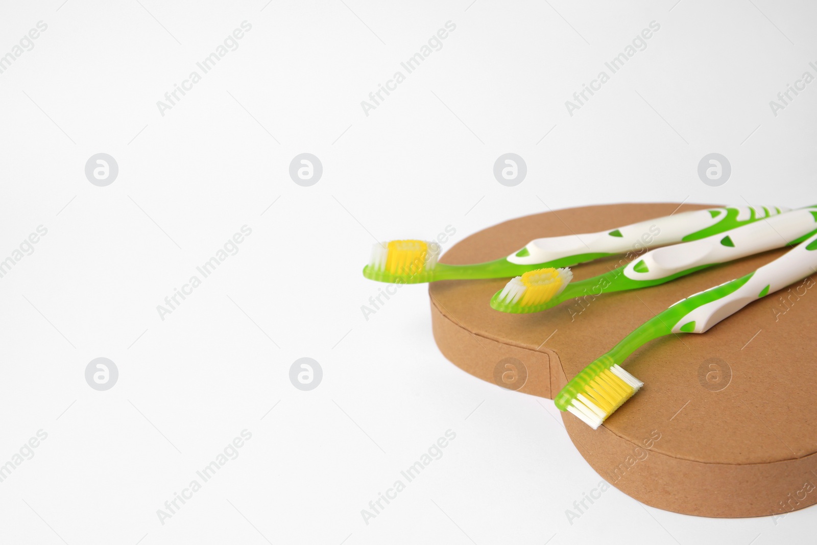 Photo of Light green toothbrushes on white background, space for text