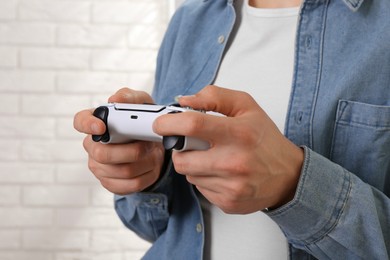 Man using wireless game controller indoors, closeup