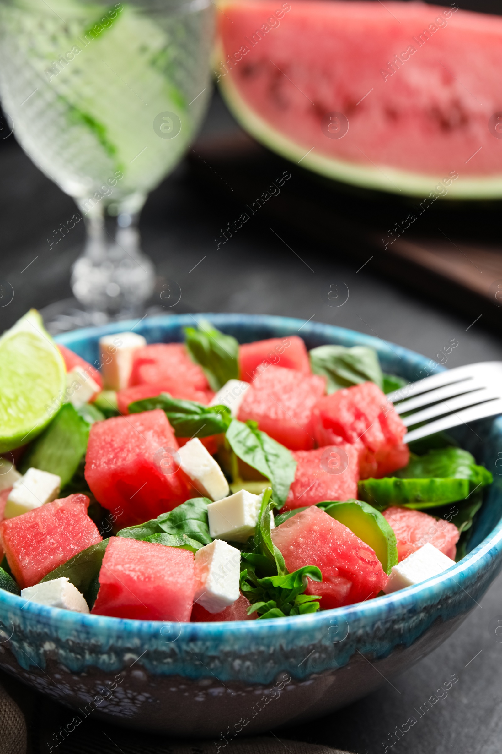 Photo of Delicious salad with watermelon served on black table, closeup