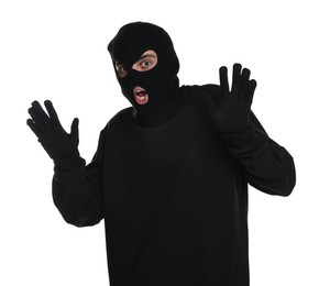 Photo of Emotional thief in balaclava raising hands on white background