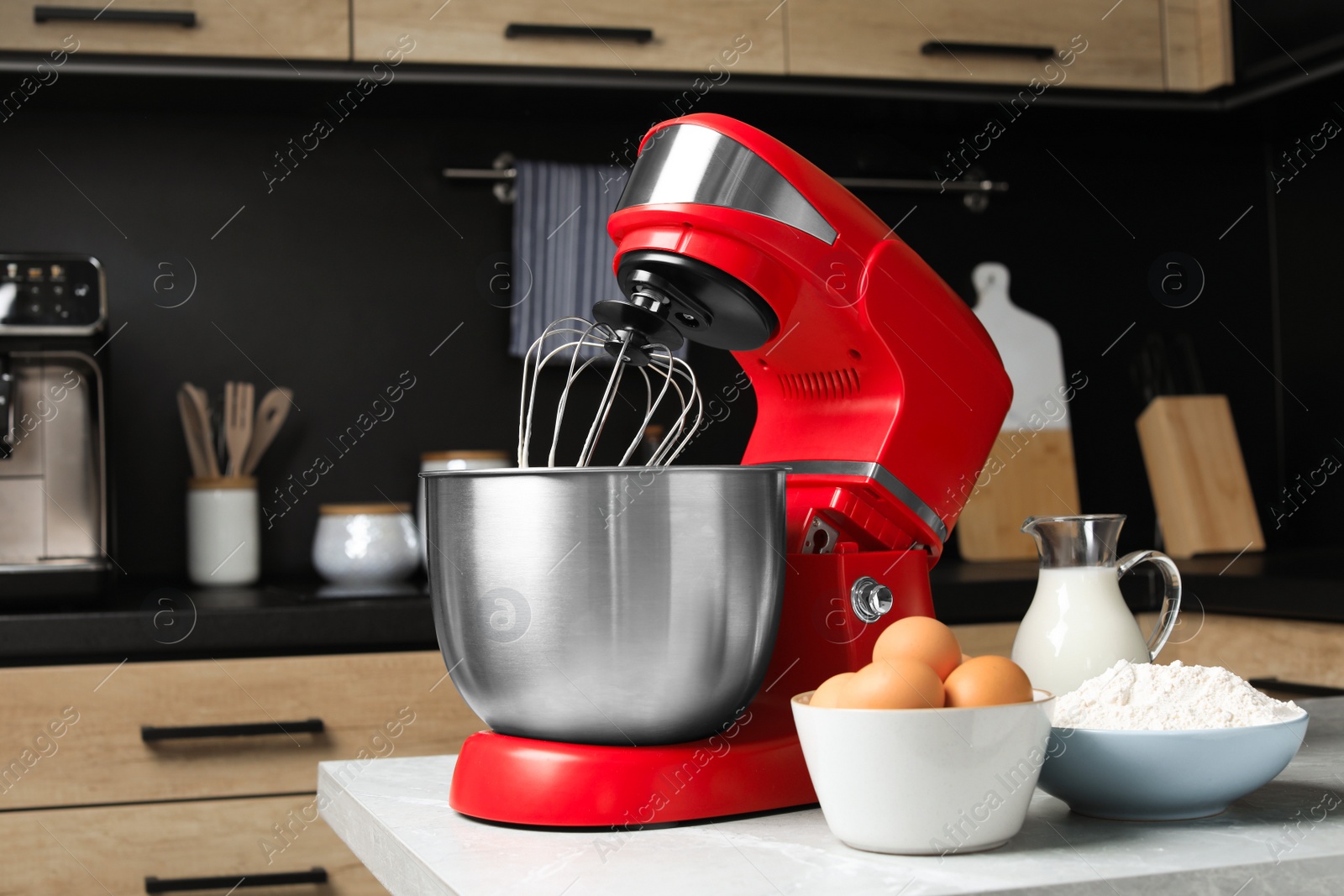 Photo of Modern stand mixer and ingredients on table in kitchen. Home appliance