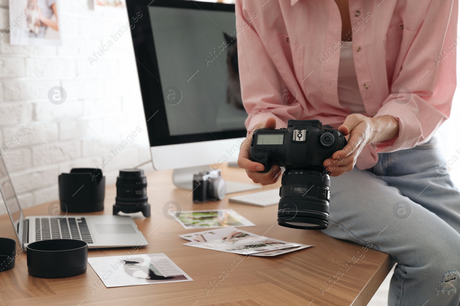 Photo of Professional photographer with camera working in office, closeup