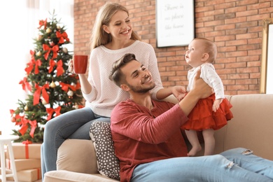 Happy couple with baby celebrating Christmas together at home