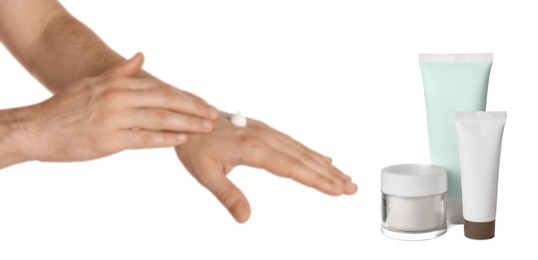 Image of Man applying cream and containers of hand care cosmetic products on white background, closeup. Banner design