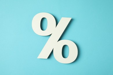 Photo of White percent sign on light blue background, top view