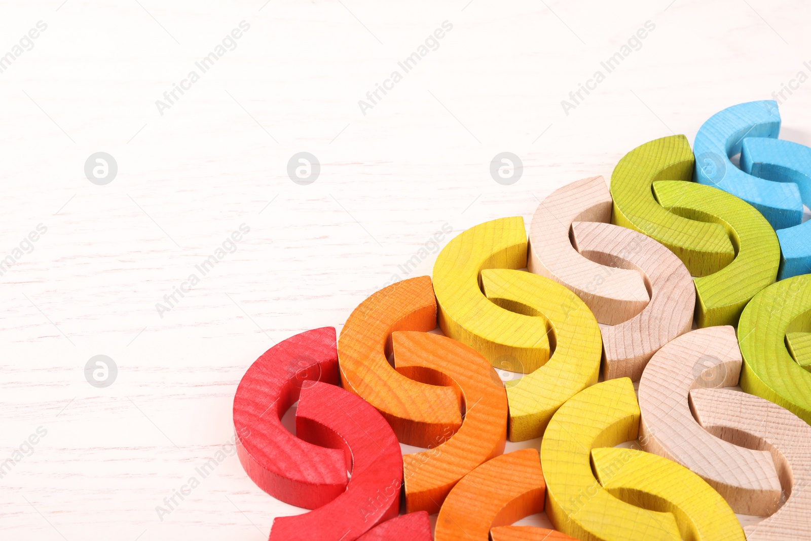 Photo of Colorful wooden pieces of playing set on white table, space for text. Motor skills development