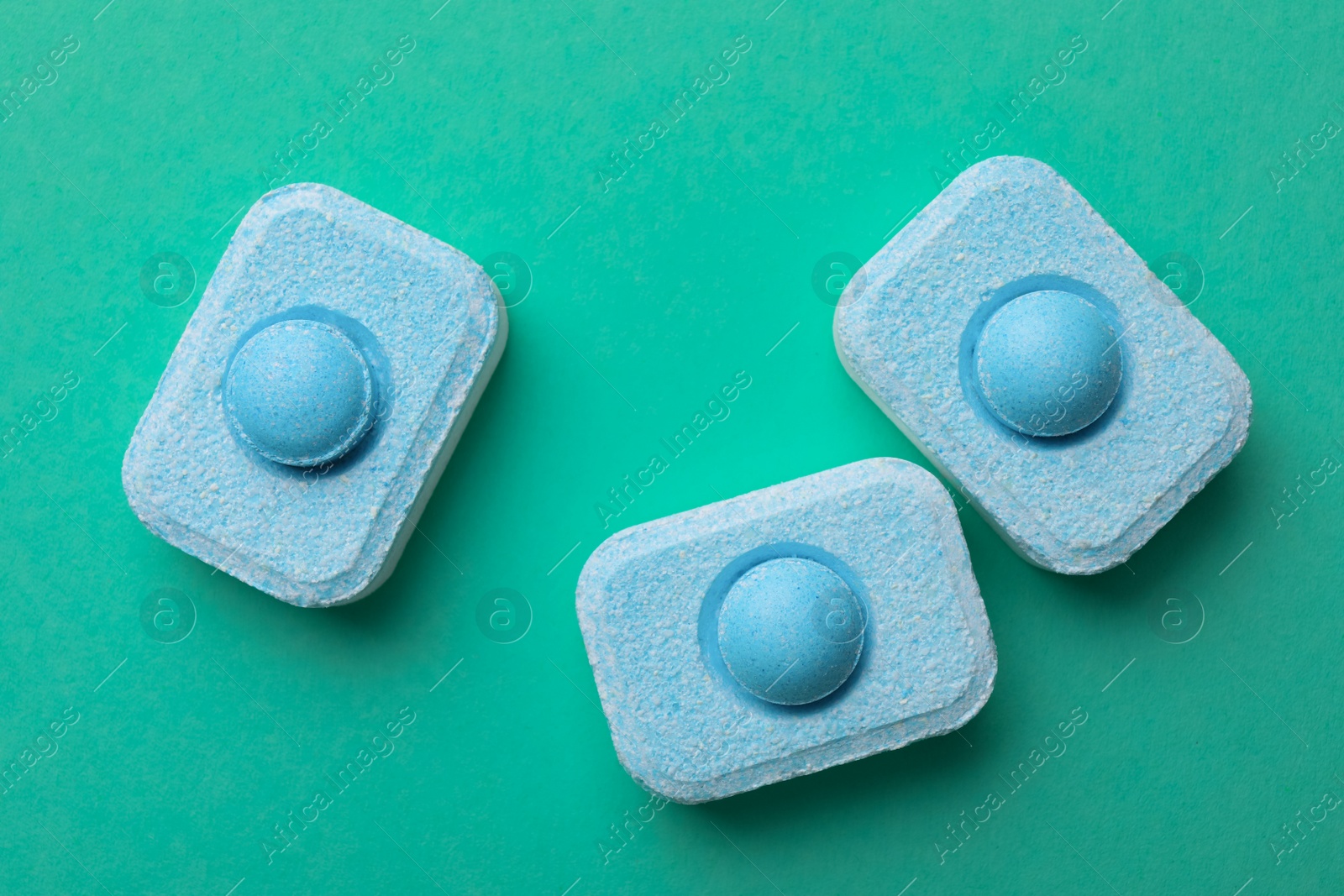 Photo of Water softener tablets on turquoise background, flat lay