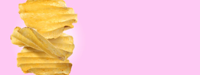 Stack of tasty ridged potato chips on light violet background, space for text