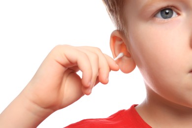 Photo of Little boy cleaning ear with cotton swab on white background, closeup