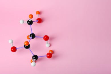 Molecule of sugar on pink background, top view and space for text. Chemical model