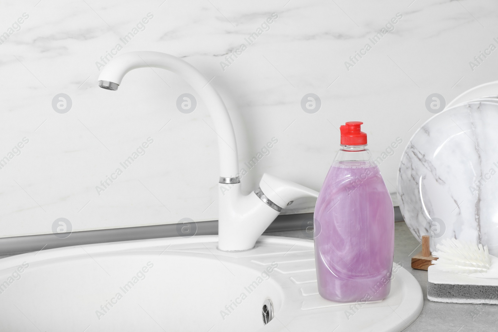 Photo of Cleaning product for dish washing near kitchen sink