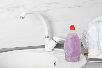 Photo of Cleaning product for dish washing near kitchen sink