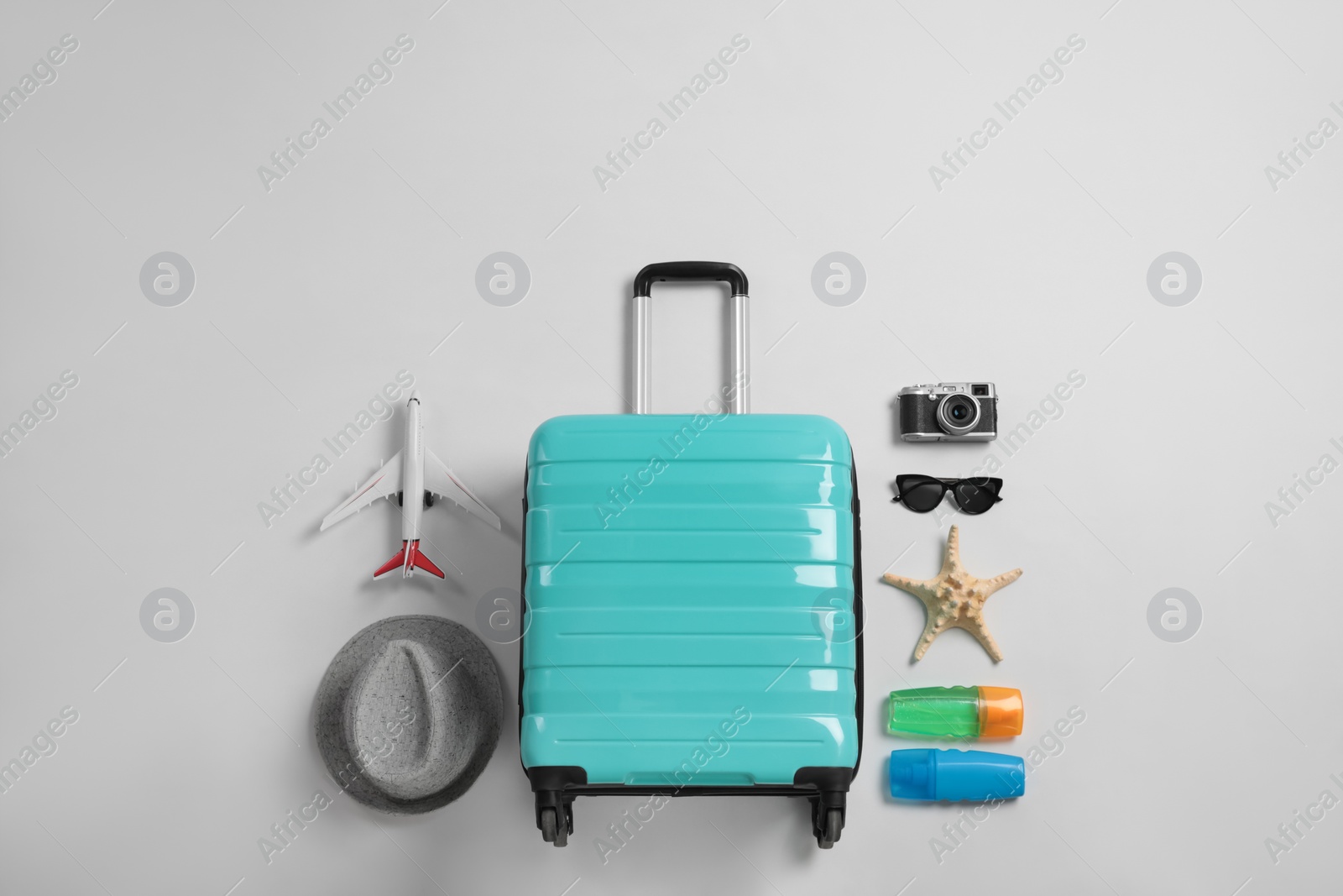 Photo of Flat lay composition with suitcase and travel accessories on grey background. Summer vacation