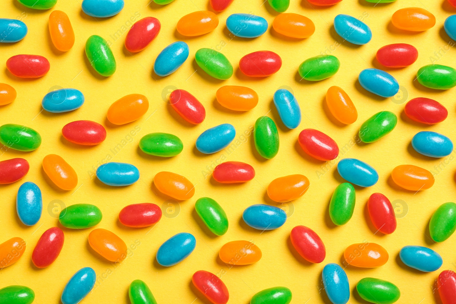 Photo of Flat lay composition with delicious jelly beans on color background