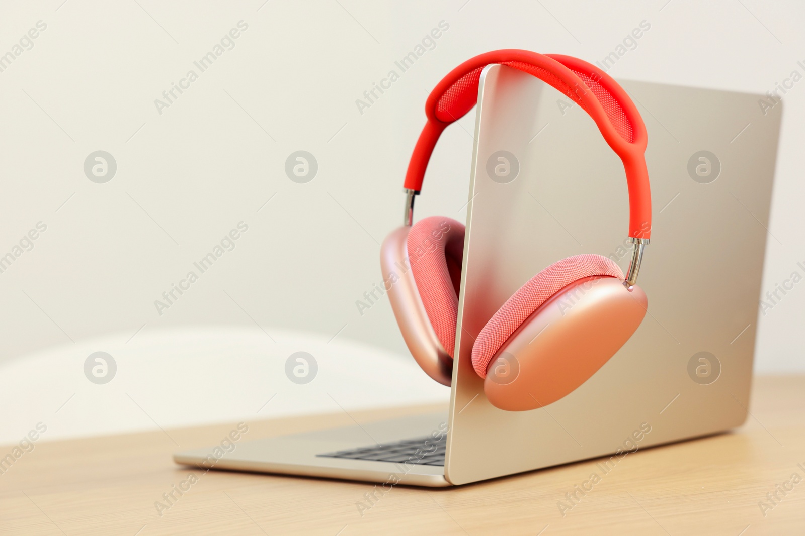 Photo of Modern laptop and headphones on wooden table. Space for text