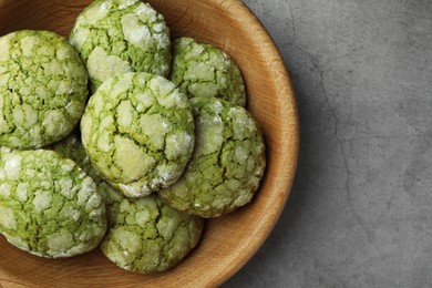 Bowl with tasty matcha cookies on grey textured table, top view. Space for text