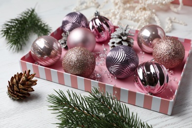 Photo of Composition with beautiful Christmas baubles on white wooden table