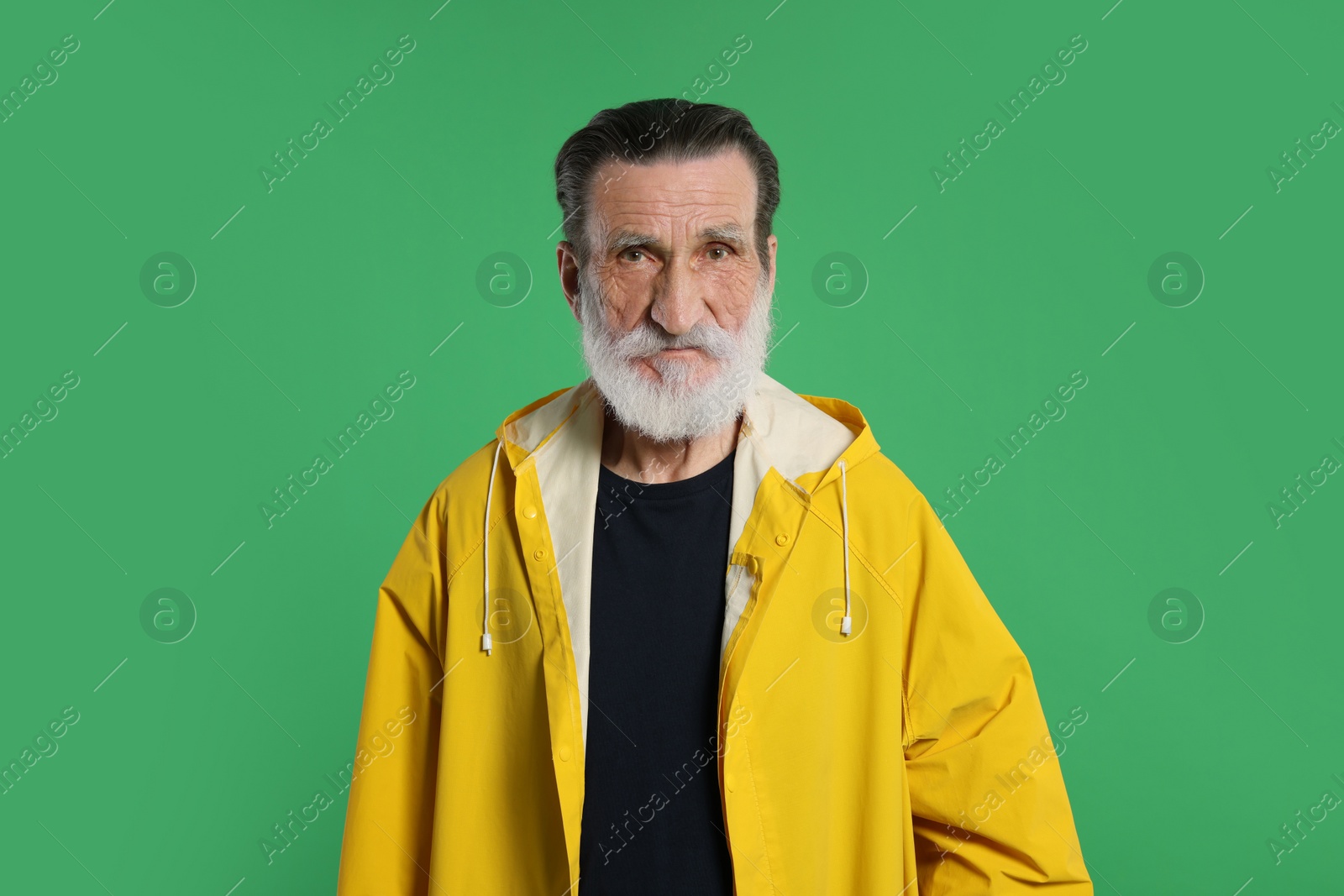 Photo of Fisherman in yellow raincoat on green background