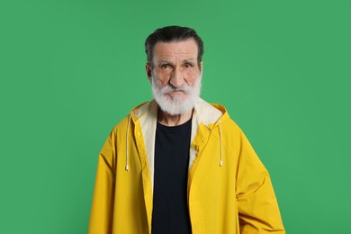 Fisherman in yellow raincoat on green background