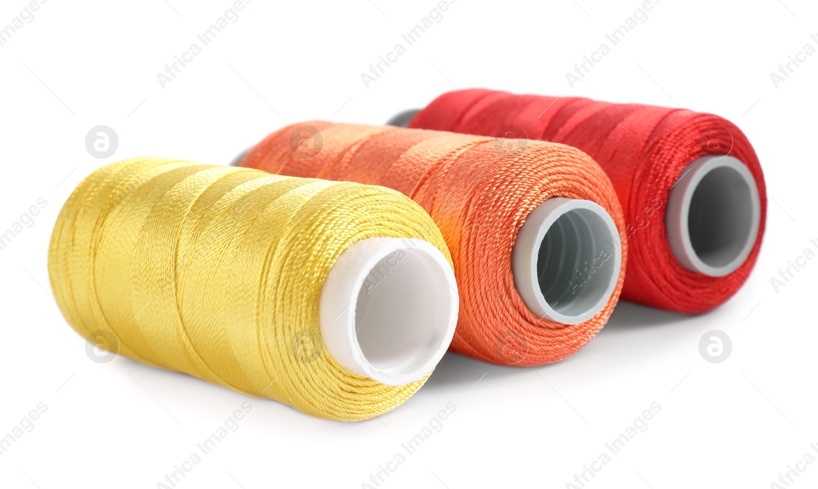 Photo of Set of colorful sewing threads on white background