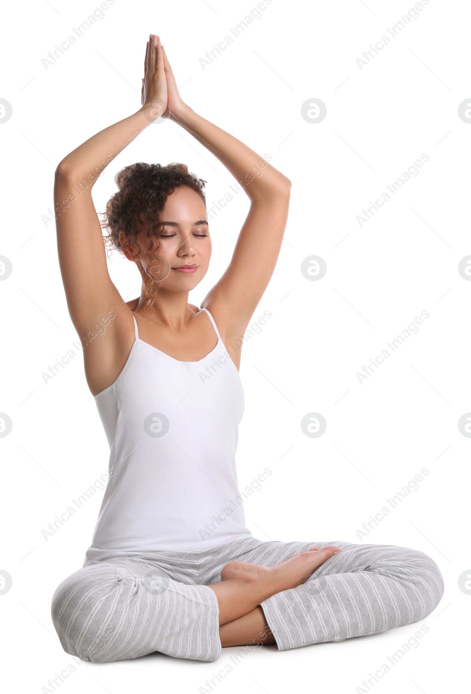 Photo of Beautiful African-American woman meditating on white background