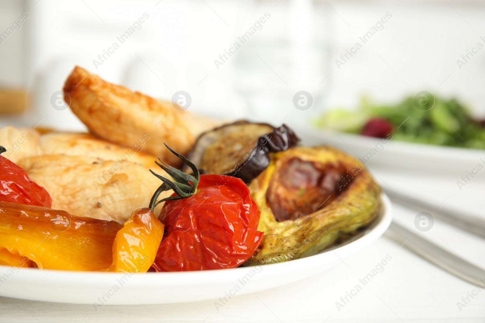 Photo of Tasty cooked chicken fillet and vegetables served on white wooden table in kitchen. Healthy meals from air fryer