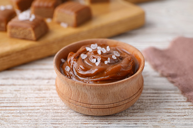 Photo of Delicious salted caramel on white wooden table