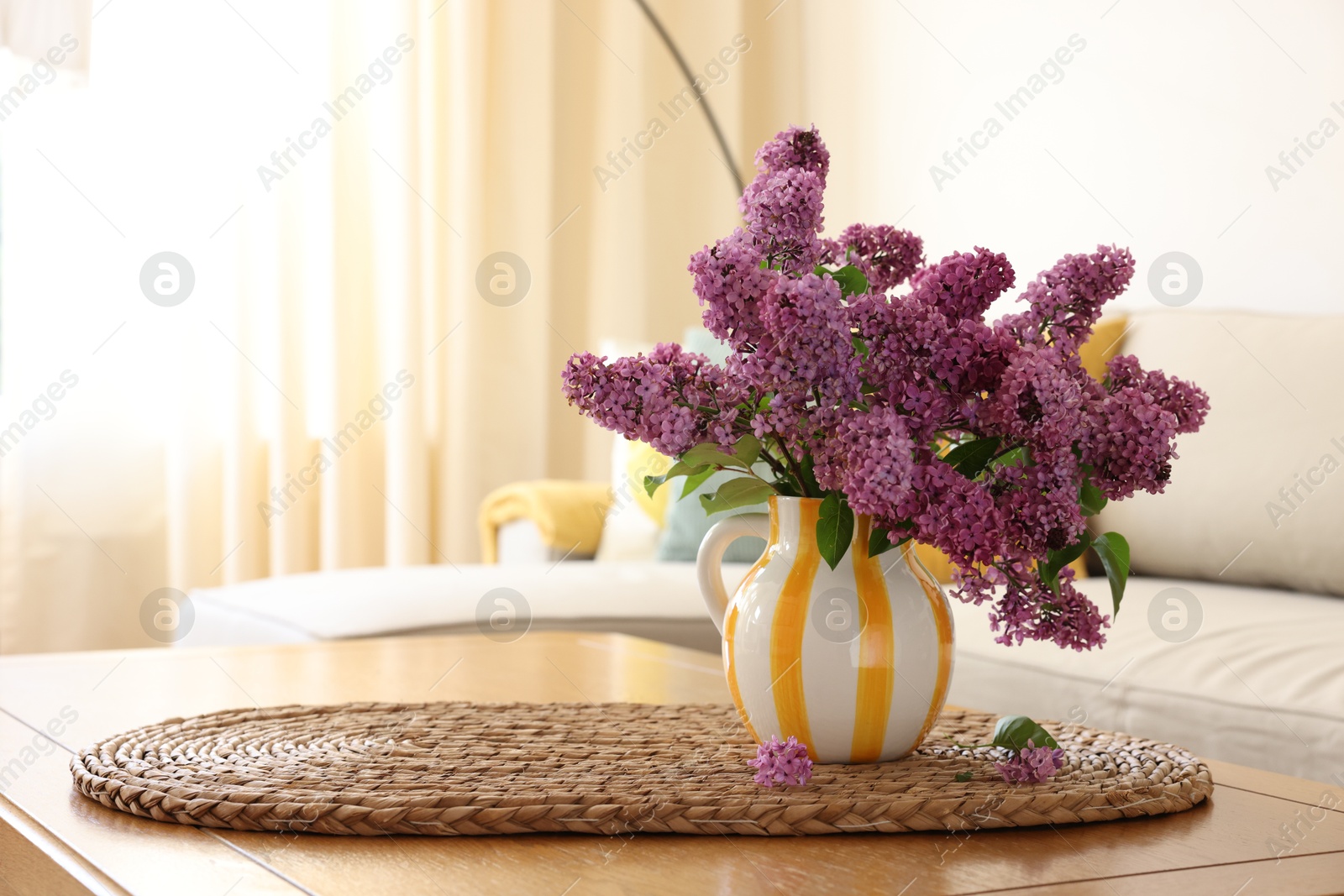 Photo of Beautiful fragrant lilac flowers in vase on table at home. Space for text