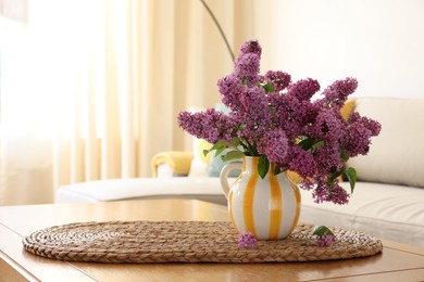 Photo of Beautiful fragrant lilac flowers in vase on table at home. Space for text