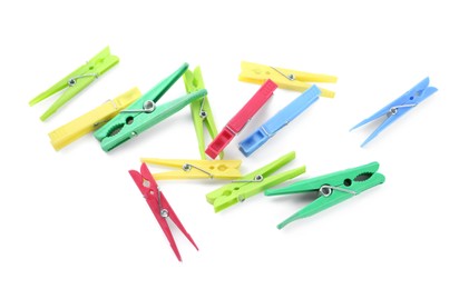 Photo of Colorful plastic clothespins on white background, above view