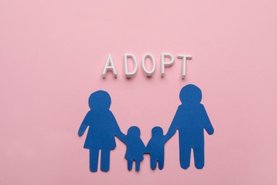 Photo of Family figure and word Adopt on pink background, flat lay