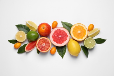 Photo of Fresh juicy citrus fruits with green leaves on light background, flat lay