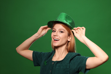 Photo of Young woman in green outfit on color background. St. Patrick's Day celebration
