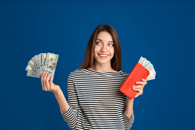 Photo of Happy young woman with cash money and wallet on blue background