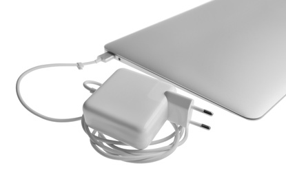 Photo of Laptop and charger on white background. Modern technology