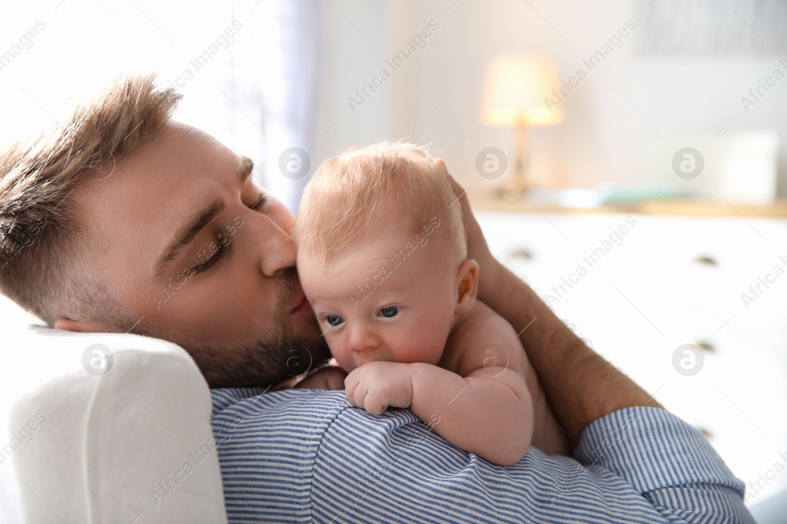 Photo of Father with his newborn son at home