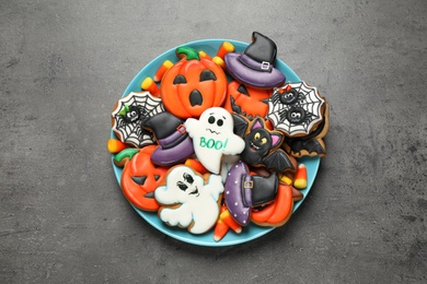 Tasty cookies and sweets for Halloween party on black table, top view