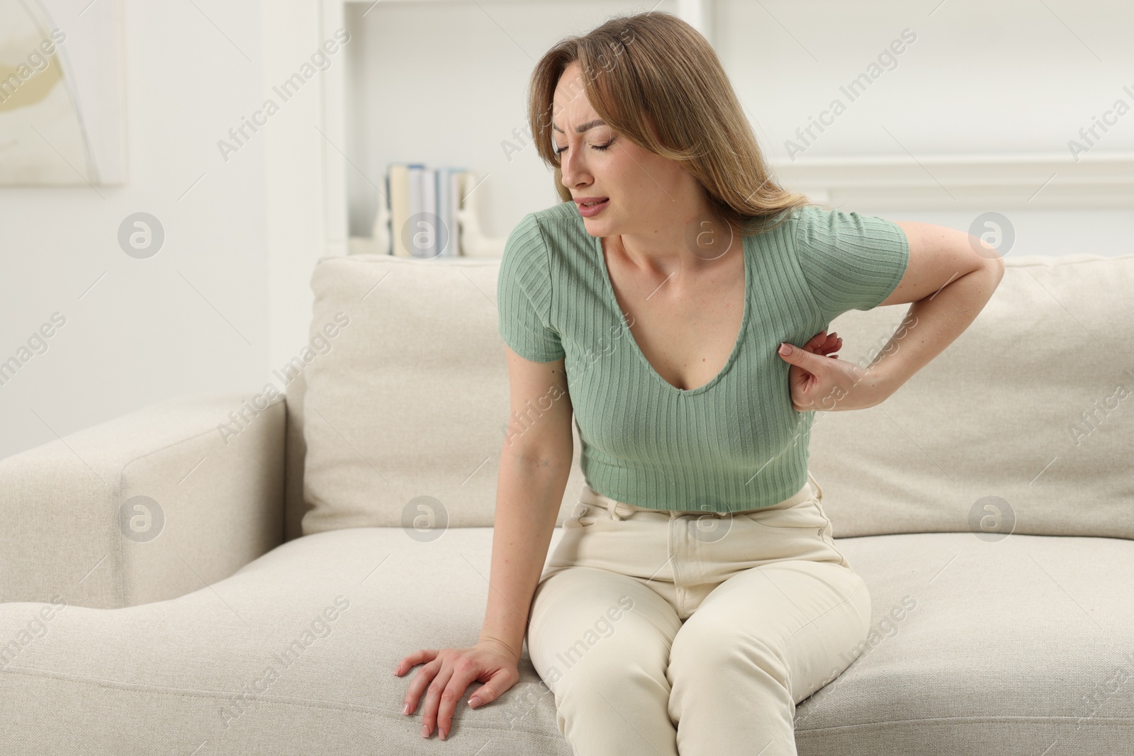 Photo of Mammology. Young woman doing breast self-examination at home