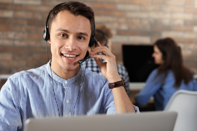 Photo of Technical support operator with headset in modern office